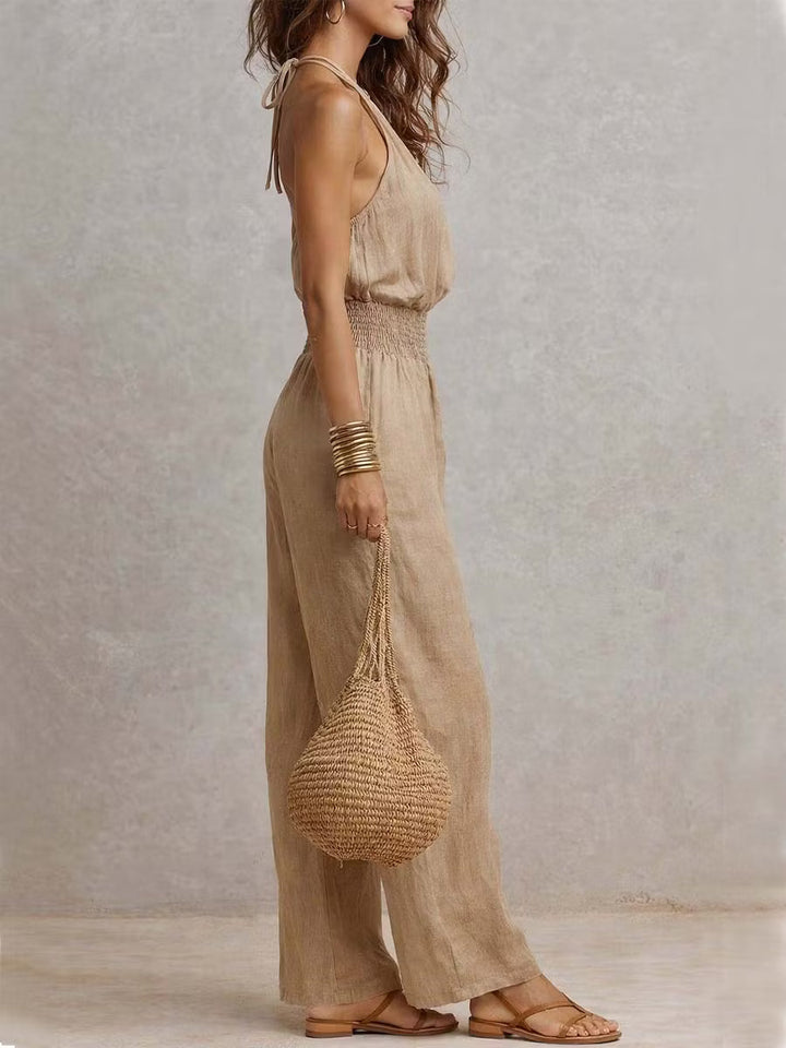 Cotton and linen jumpsuit with halter neckline, gathered waist, and wide legs.