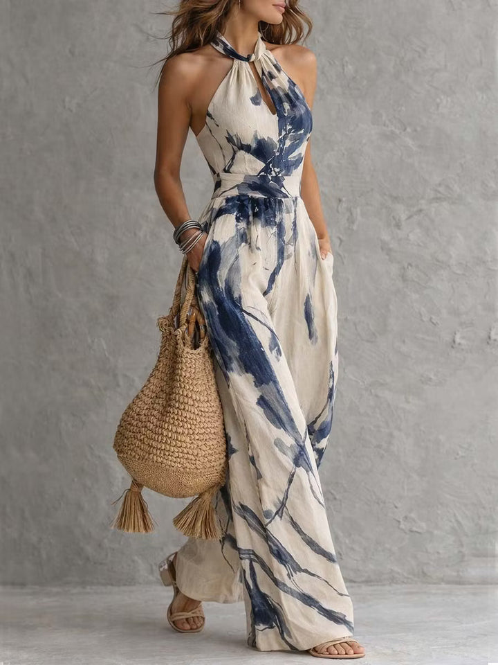 Wide-leg jumpsuit with ink wash print, halter neck, and pockets.
