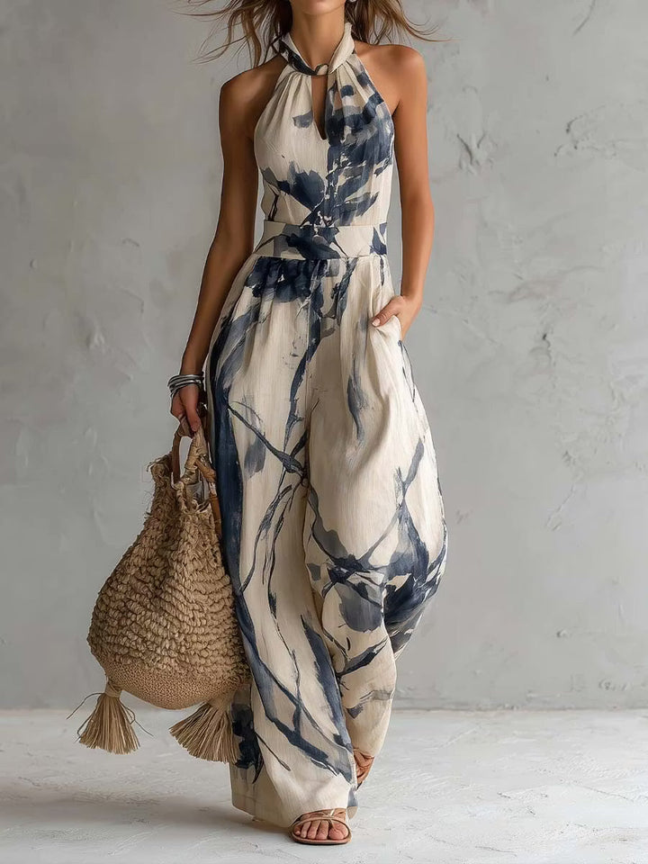 Wide-leg jumpsuit with ink wash print, halter neck, and pockets.
