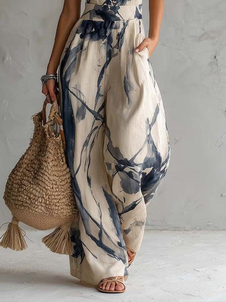Wide-leg jumpsuit with ink wash print, halter neck, and pockets.