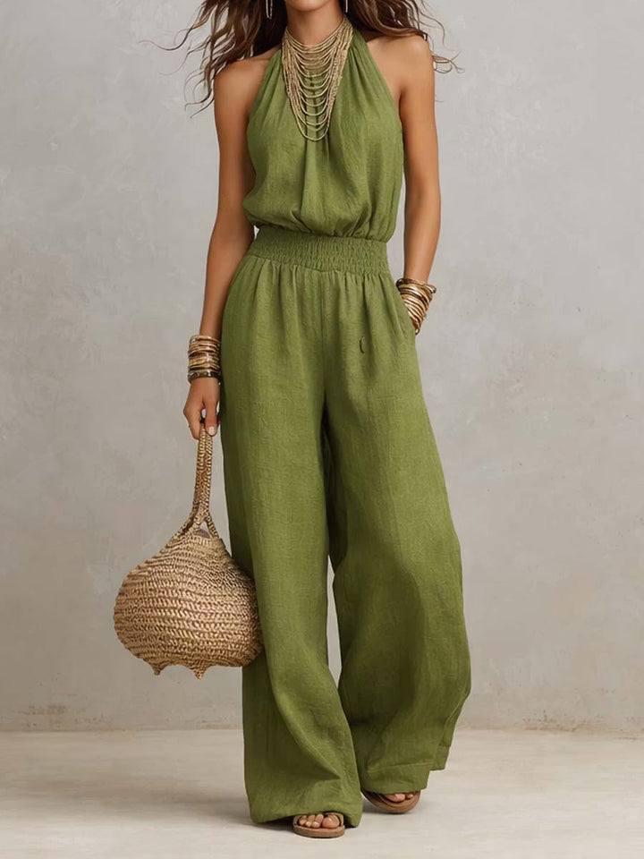 Cotton and linen jumpsuit with halter neckline, gathered waist, and wide legs.