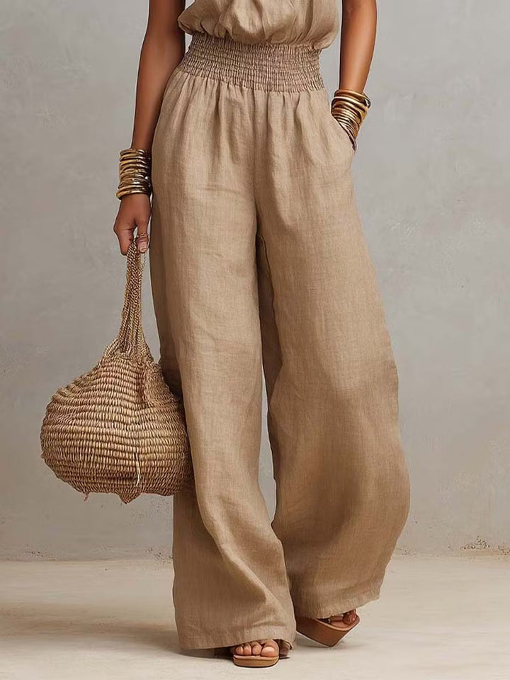 Cotton and linen jumpsuit with halter neckline, gathered waist, and wide legs.