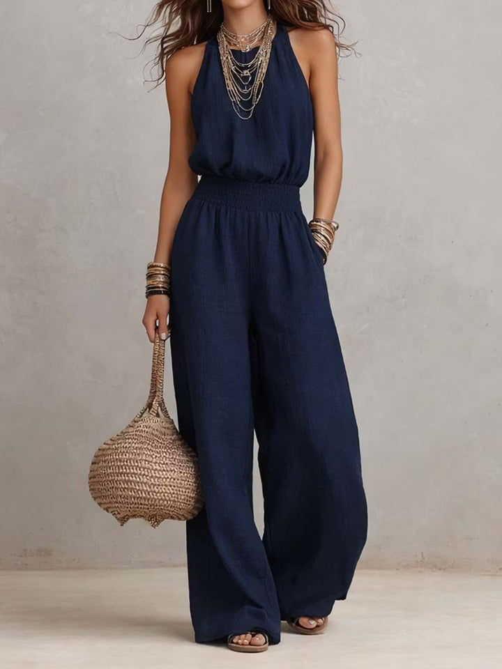Cotton and linen jumpsuit with halter neckline, gathered waist, and wide legs.
