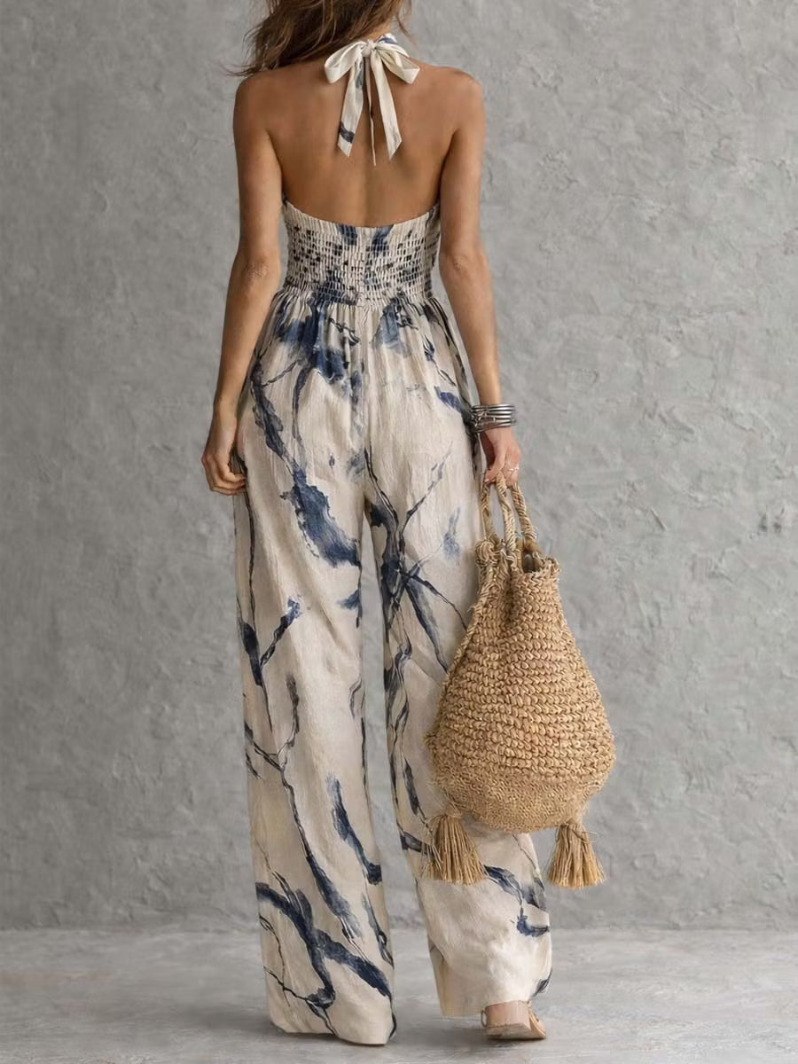 Wide-leg jumpsuit with ink wash print, halter neck, and pockets.