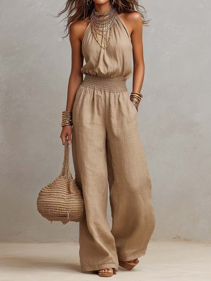 Cotton and linen jumpsuit with halter neckline, gathered waist, and wide legs.