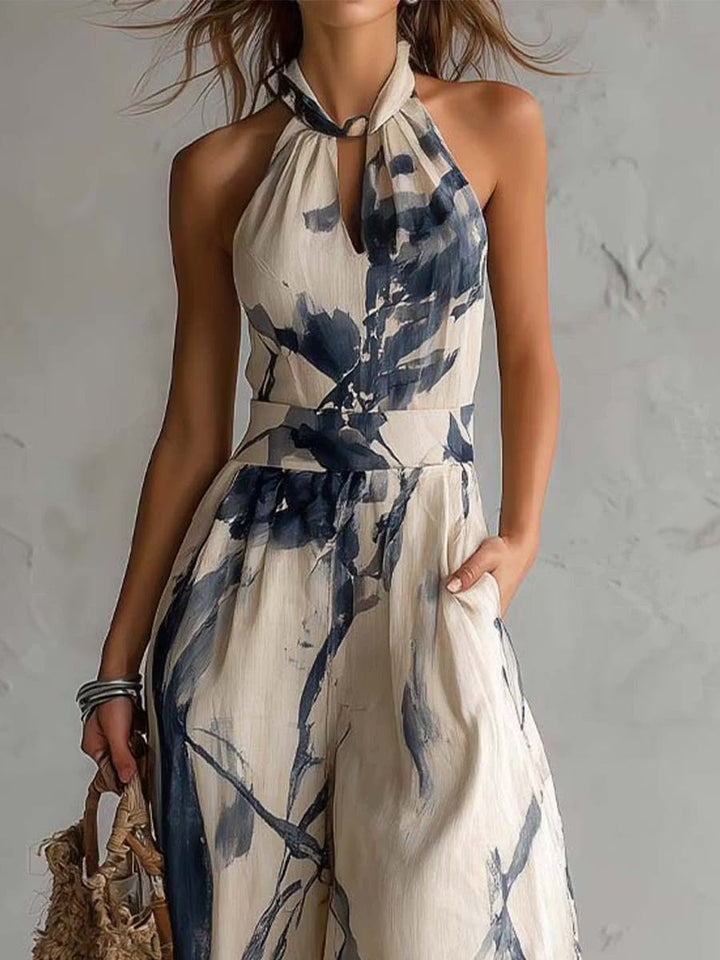 Wide-leg jumpsuit with ink wash print, halter neck, and pockets.
