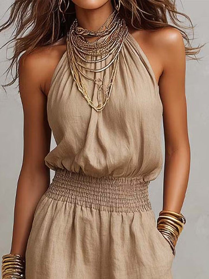 Cotton and linen jumpsuit with halter neckline, gathered waist, and wide legs.